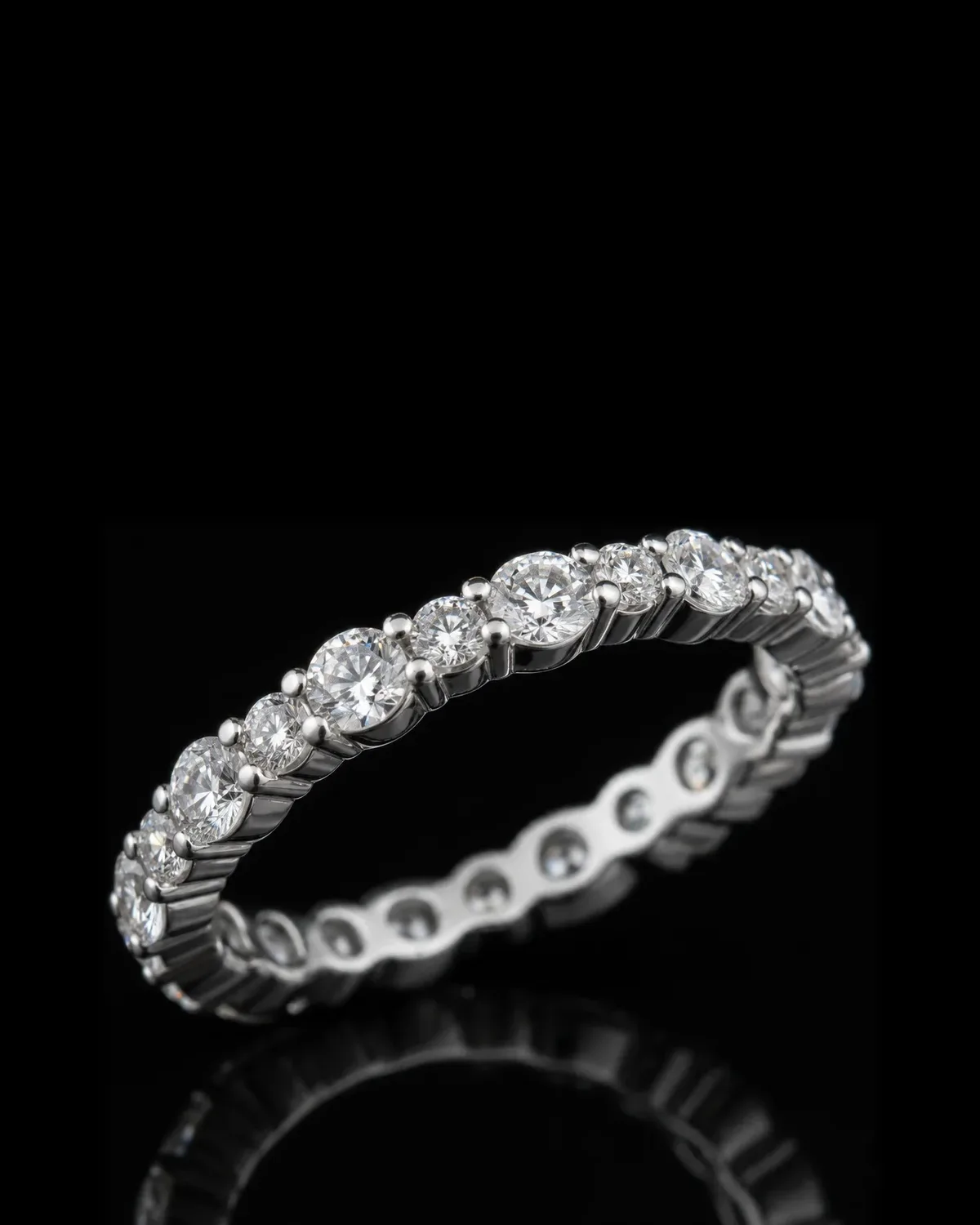 טבעת איטרניטי בזהב לבן עם שורת אבנים עגולות בשני גדלים לסירוגין